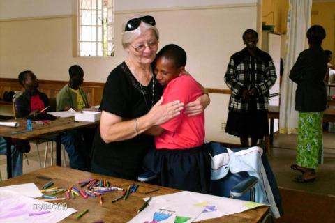 Maryknoll Sister Mary Frances Kobets (left) hugs a student in Zimbabwe